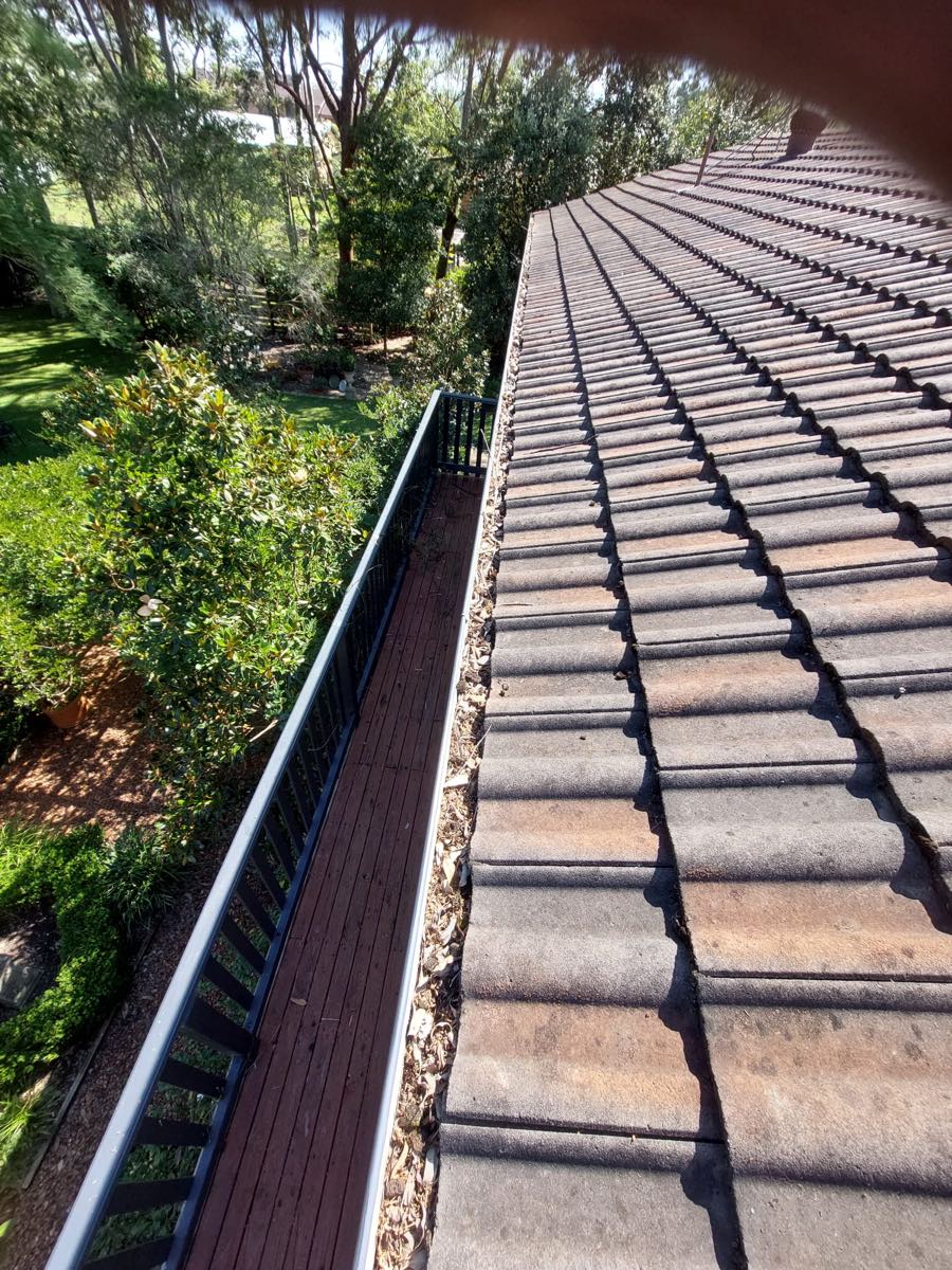 The same gutter run after cleaning, draining freely