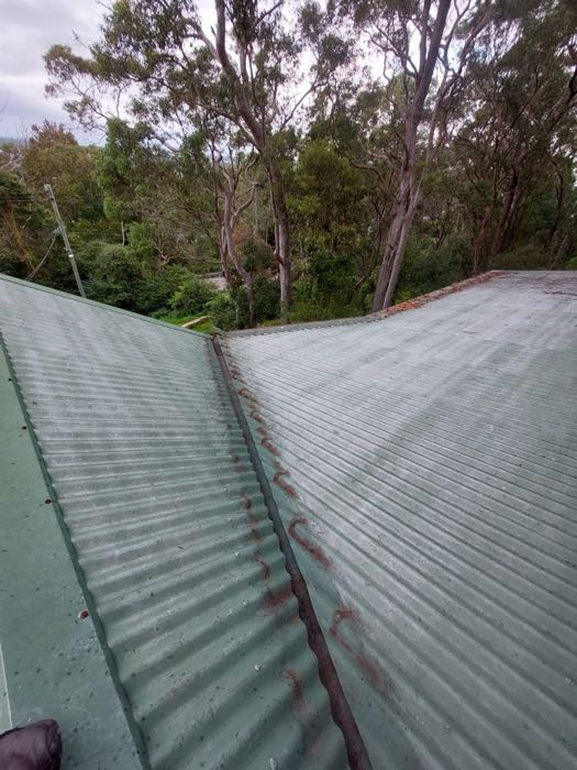 Roof valley with debris build-up and rust staining