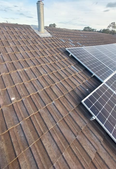 Tile roof after repair with fresh ridge pointing and replaced tiles