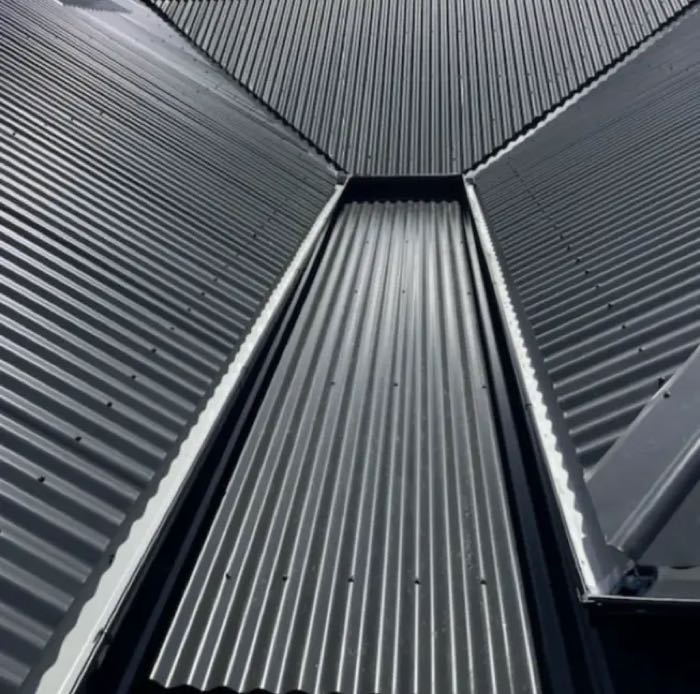 Powder-coated aluminium gutter guard mesh installed along a roof edge