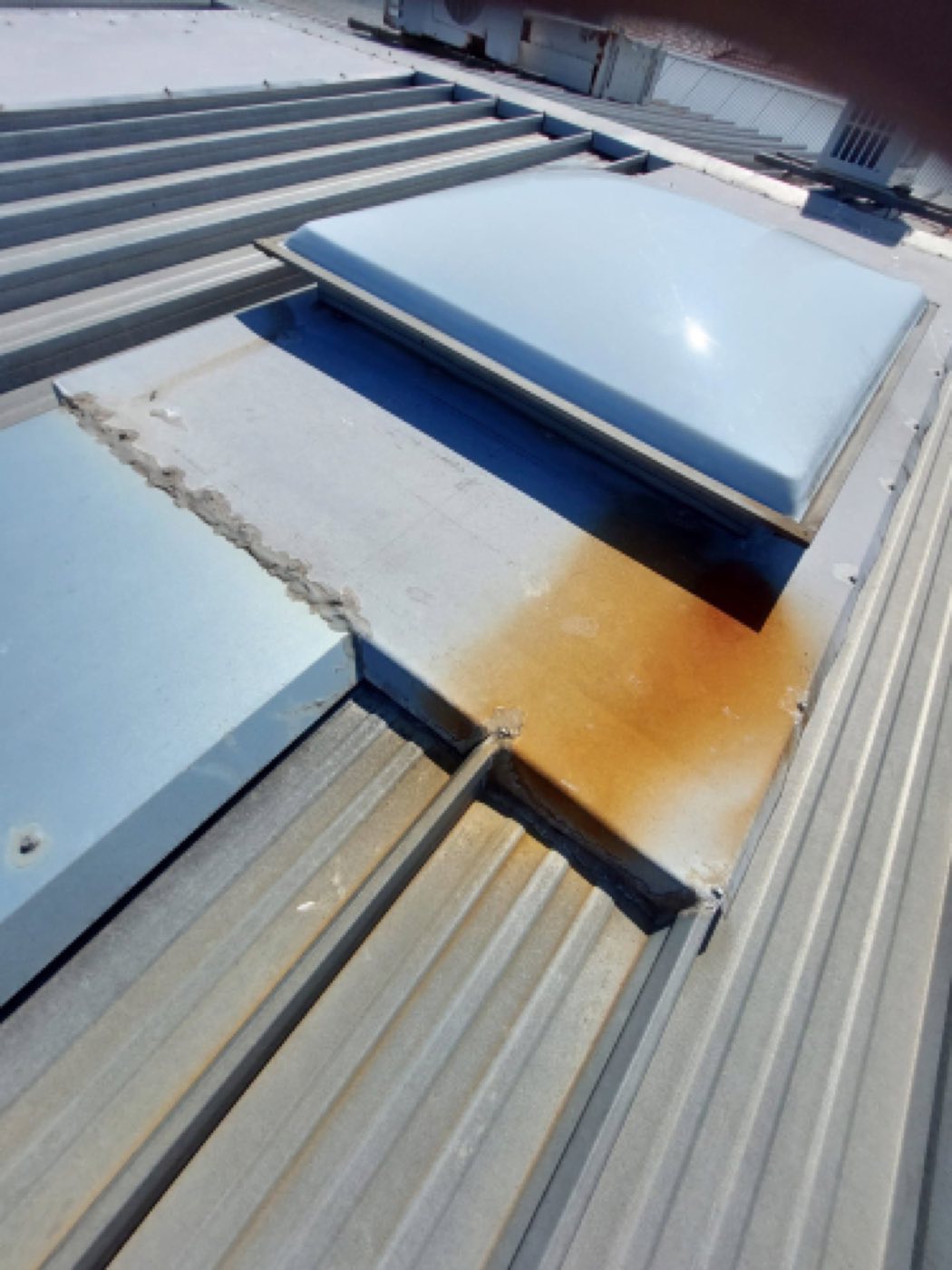 Roof penetration flashing with rust staining from long-term water ingress